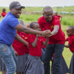 Community members volunteering at education charity in Tanzania